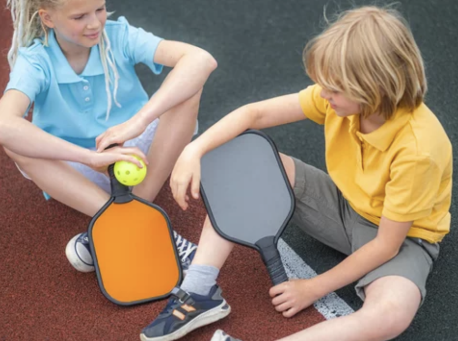 kids sitting on pickleball court